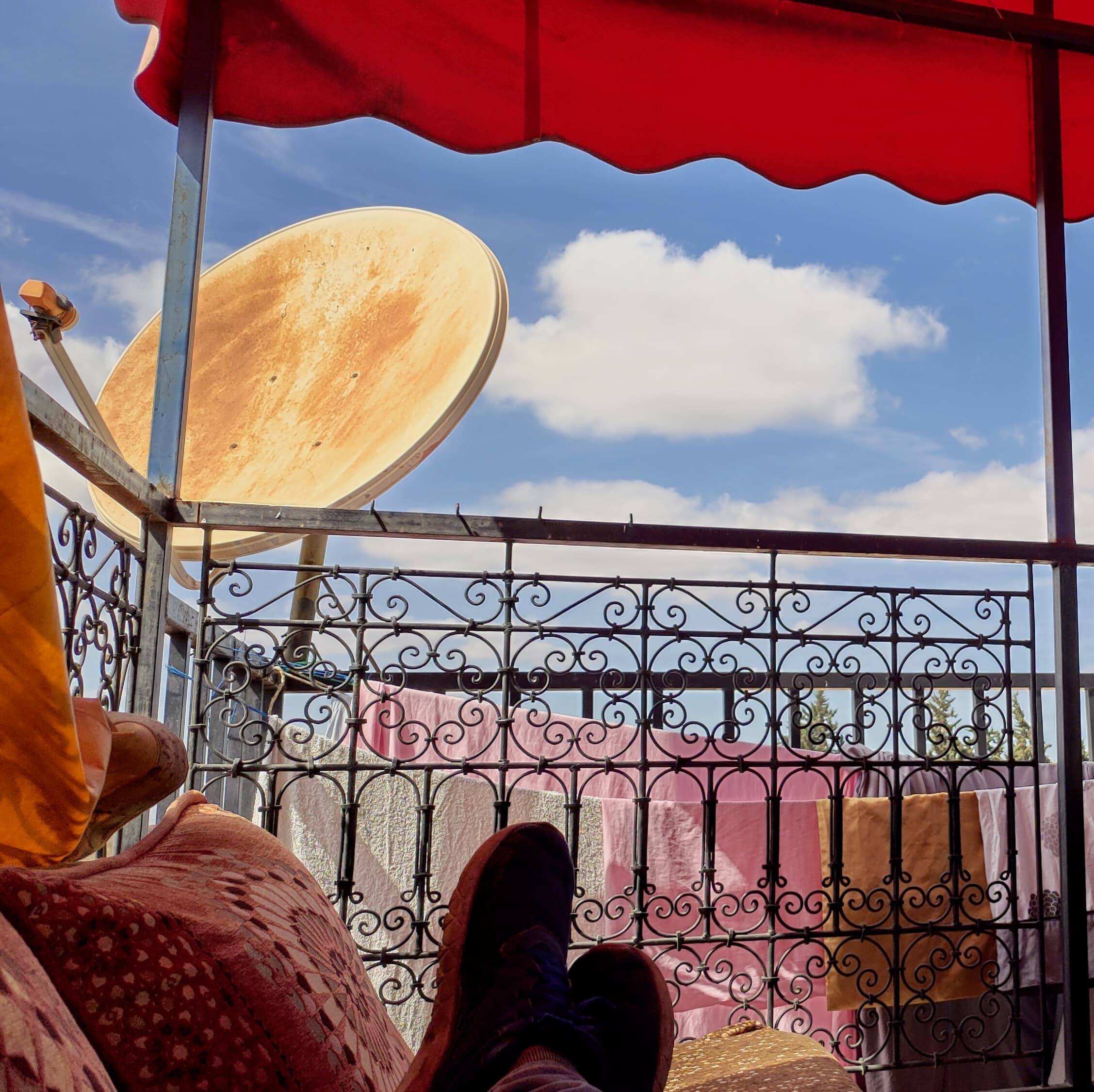 Putting my feet up on the Hostel terrace, against a backdrop of blue skies and a colourful canvas roof